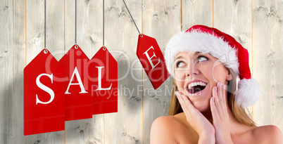 Composite image of festive blonde with hands on face