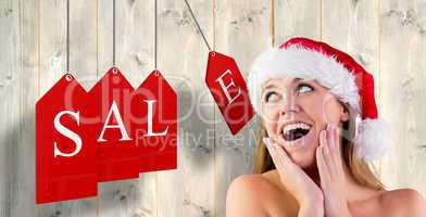 Composite image of festive blonde with hands on face