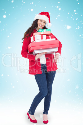 Composite image of festive brunette in santa hat and red coat ho