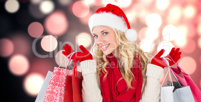 Composite image of happy festive blonde with shopping bags