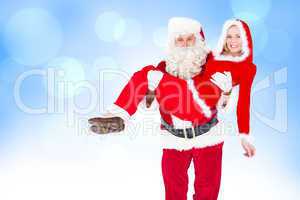 Composite image of santa and mrs claus smiling at camera