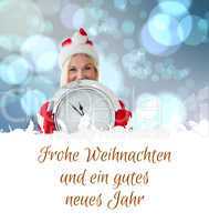 Composite image of happy festive blonde with clock