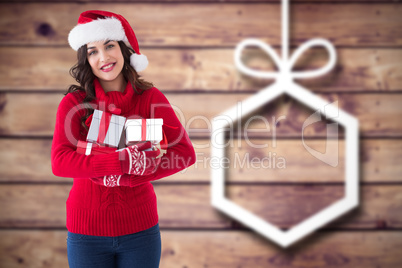 Composite image of festive brunette holding many gifts
