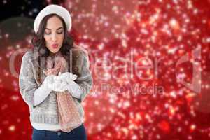 Composite image of pretty brunette in winter clothes blowing