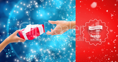 Composite image of couple passing a wrapped gift