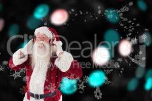 Composite image of santa claus enjoys some music