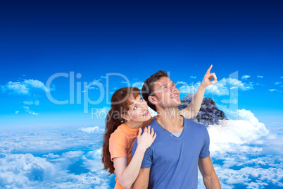 Composite image of happy couple looking upwards