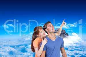 Composite image of happy couple looking upwards