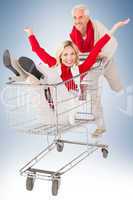 Composite image of happy festive couple messing in trolley