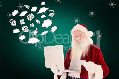 Composite image of santa pays with credit card on a laptop