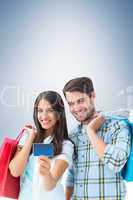 Composite image of couple with shopping bags and credit card