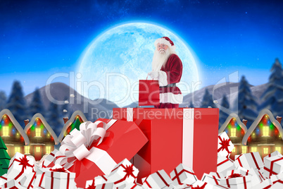 Composite image of santa standing in large gift