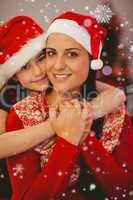 Composite image of festive mother and daughter smiling at camera