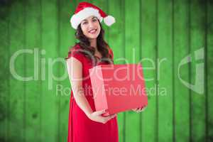 Composite image of festive brunette holding red box