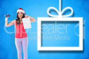 Composite image of festive athletic brunette holding page and du