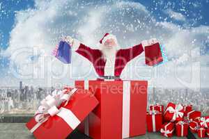 Composite image of santa standing in large gift