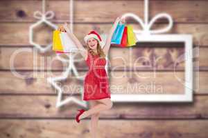 Composite image of pretty woman in santa hat holding up shopping