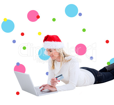 Composite image of festive blonde shopping online with laptop