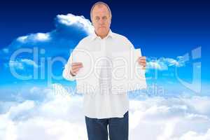 Composite image of serious man holding torn sheet of paper