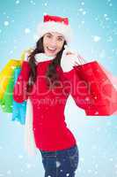 Composite image of festive brunette in winter wear holding shopp