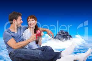 Composite image of couple having tea on floor