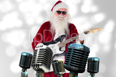 Composite image of santa claus plays guitar with sunglasses