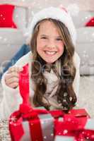 Composite image of festive little girl smiling at camera with gifts