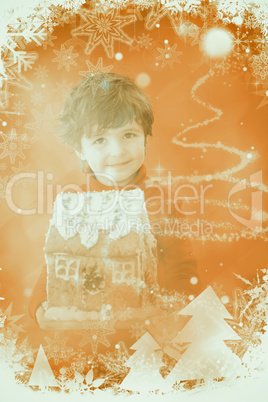 Composite image of festive little boy holding gingerbread house