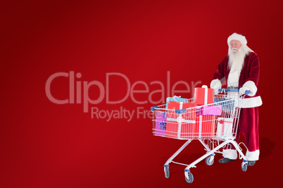 Composite image of santa pushes a shopping cart with presents