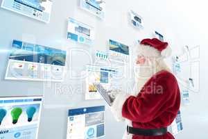 Composite image of santa uses a tablet pc