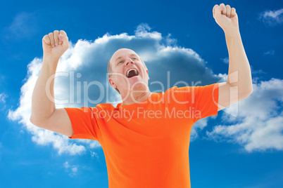 Composite image of mature man in orange tshirt cheering