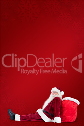 Composite image of santa sits leaned on his bag