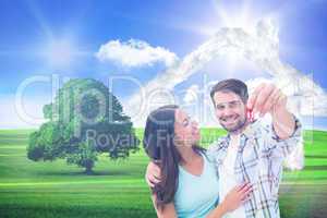 Composite image of happy young couple showing new house key