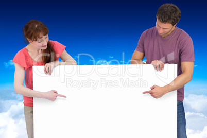 Composite image of couple looking at a sign