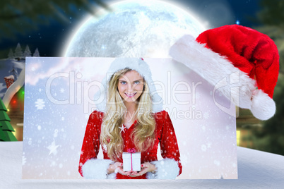 Composite image of pretty girl in santa outfit holding gift