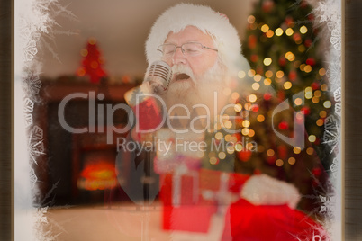 Composite image of santa claus is singing christmas songs