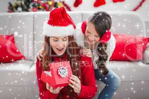 Composite image of festive mother and daughter with a christmas