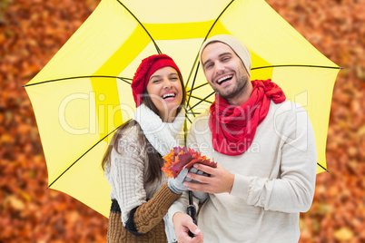 Composite image of autumn couple holding umbrella