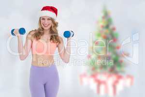 Composite image of festive fit blonde holding dumbbells