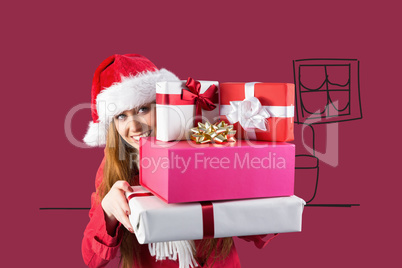 Composite image of festive redhead holding pile of gifts