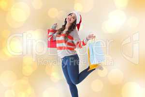 Composite image of festive brunette posing with shopping bags