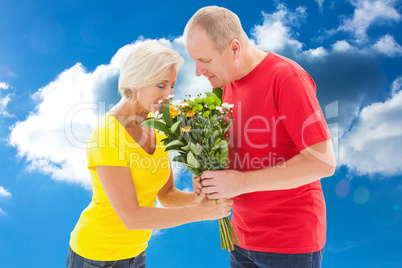 Composite image of mature man offering his partner flowers