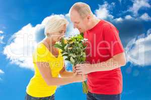 Composite image of mature man offering his partner flowers