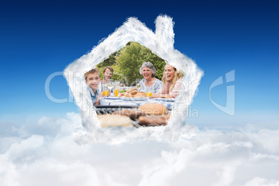 Composite image of laughing family having a barbecue in the park