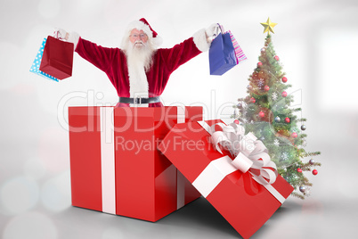 Composite image of santa standing in large gift