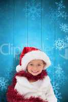 Composite image of cute little girl wearing santa hat and tinsel