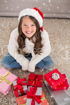 Composite image of festive little girl smiling at camera with gifts