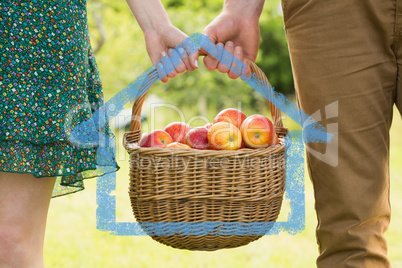 Composite image of basket of apples being carried by a young cou
