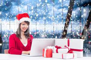 Composite image of festive brunette shopping online with laptop