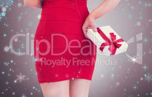 Composite image of woman in red dress holding gift